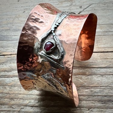 A wide copper bangle with fused and reticulated silver and a small garnet