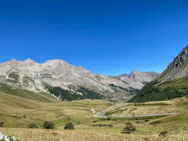 Blick auf die Berge der Grand Alpes in Frankreich,  mit einer kurvigen Passstrasse im Vordergrund