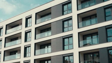 A business traveler sitting at a sleek desk in a modern apartment, looking focused, Zentraleuropäisch / Deutsch setting.
