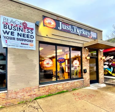 Just Turkey restaurant exterior with a black-owned business support banner and neon open sign.