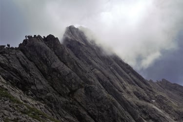 gratwanderung menschen ausgesetzt sonne und wolken steil fels