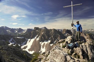 allgaeuer alpen bergsteiger gipfel sonne kreuz wolken