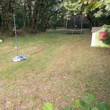 Grand jardin arboré avec terrain de volley, badminton et jeux de plein air pour toute la famille.