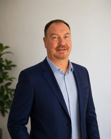Professional portrait of a businessman with a handlebar mustache wearing a navy blue blazer.