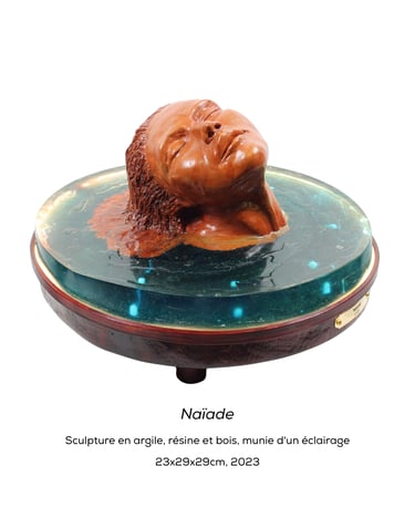 Sculpture de l'artiste Lode intitulée Naïade, représentant le buste d'une femme dans l'eau.  