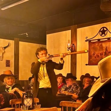 Moonshine Saloon bar owner pointing his rifle at the Out Laws in Valley, Brisbane - party hire by SweetAz Co.