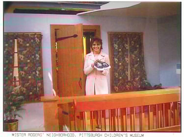 Angela Santomero holding Mister Rogers' sneakers on set in Pittsburgh, PA