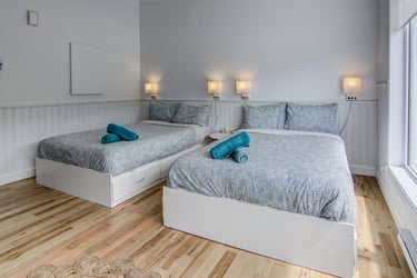 Chambre généreuse à l'Auberge du Yéti, offrant confort et panoramas spectaculaires sur les Monts-Valin.