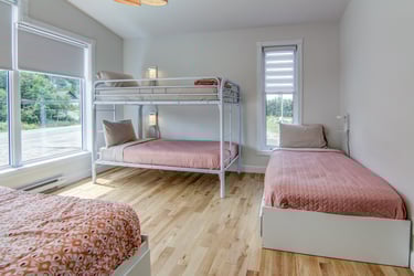 Chambre spacieuse à l'Auberge du Yéti, idéale pour se détendre et profiter de la vue sur les Monts-Valin.