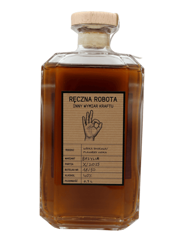 Szklana butelka wódki o smaku bazylii z drewnianym korkiem i ręcznie napisaną etykietą.