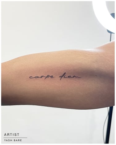 Photo of a carpe diem tattoo on the inner arm
