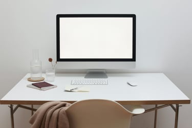 Minimalist home office desk featuring a silver computer monitor with a blank white screen.