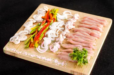 Pollo picado con verduras en tabla