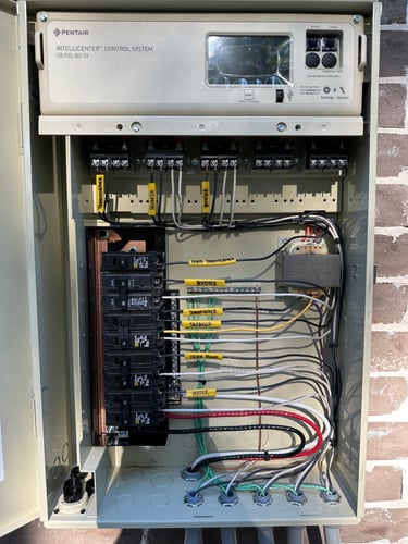 Pentair IntelliCenter pool and spa control system panel with labeled circuit breakers and wiring.