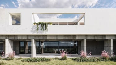 Una galería en planta baja, en homrigón visto y el contraste con una terraza en planta alta en blanco puro. casa minimalista