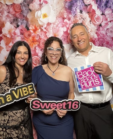 Family and friends celebrating a Sweet 16 with prop signs at a photo booth rental Nassau County NY