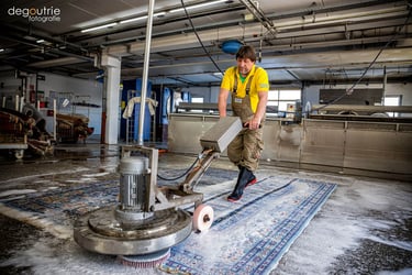 Professionelle Teppich Reinigung in der Industrie. Mitarbeiter arbeitet an professioneller Maschine.