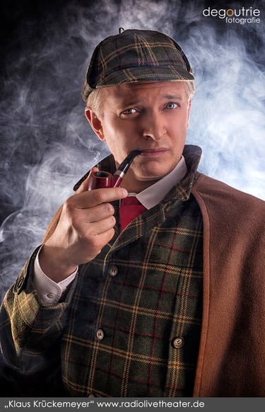 Künstlerportrait von Klaus Krückemeyer als Sherlock Holmes mit Rauch im Fotostudio Hanau.