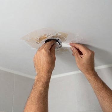 Close-up of a wall showing various damages like holes, cracks, and water stains.