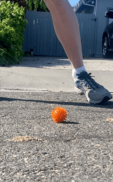 Street golf ball on a pavement before being hit by a golf club
