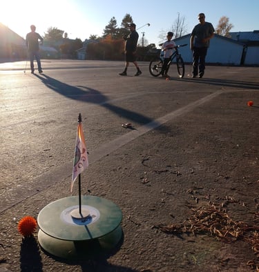Street golf competition with three men putting in empty parking lot