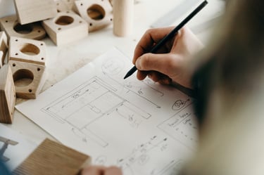 Hand drawing custom furniture design blueprints and woodwork sketches with a pencil.