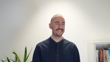 a bald man in a blue shirt smiling