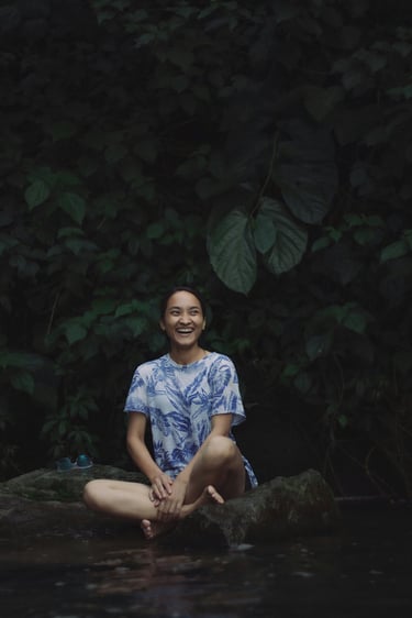 woman in nature smiling in meditation pose