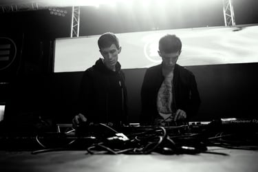 Twins brothers standing in front of a stage with a large screen