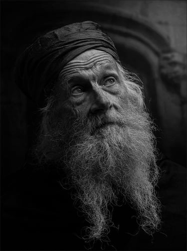 Black and white street image of bearded homeless man by Carol Visser.