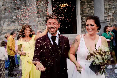 Sortie des marié.e.s du château de Waroux sous une plui de pétales de fleurs