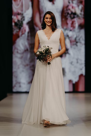 Modèle féminin portant une robe de mariée lors d'un défilé au salon du mariage de Liège