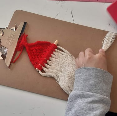 manos cepillando cordón de algodón de un santa de navidad, accesorio navideño de macramé