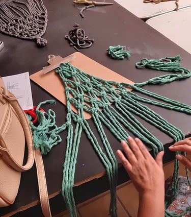 manos tejiendo macramé con cordón color verde aqua