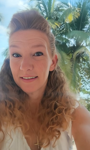 Marcie Ledbetter with curly hair smiles during a vacation with palm trees in the background.