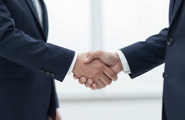 A professional handshake between two people in business attire, conveying a sense of partnership and reliability.