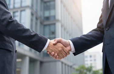 Two professionals in business attire shaking hands in front of a modern building, symbolizing a successful partnership, lighting is bright and confident with palette accents.