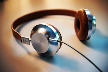 Stylish silver and brown leather over-ear wired headphones resting on a flat surface.