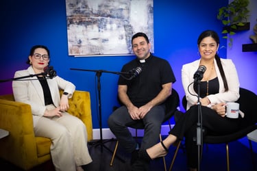 A diverse group of podcast hosts and a guest priest recording a video interview in a blue studio.