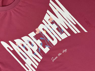 A maroon Carpe Diem t-shirt featuring bold white lettering and a delicate floral graphic design.