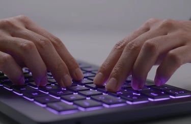 A close-up of a person's hands using a high-tech keyboard with deep purple backlit keys in a sleek, minimalist environment. Global / English-speaking.