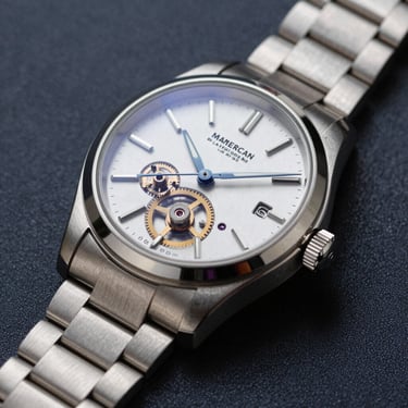 A macro photograph of a classic, high-end silver mechanical watch resting on a dark navy surface. The lighting is focused and dramatic, highlighting the intricate gears. North American luxury style, conveying stability.