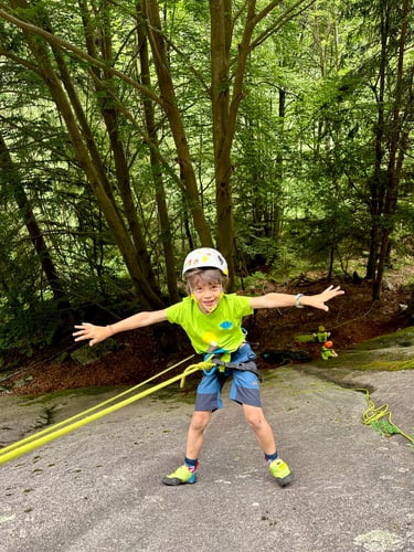 A happy kid learns how to be lowered down