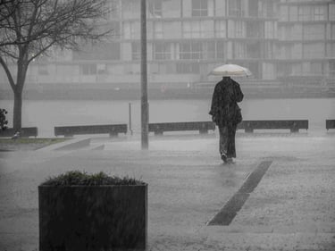 Woman walking with umbrella in downpour.
