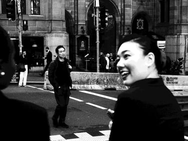 A woman talks to a friend just before crossing the road.