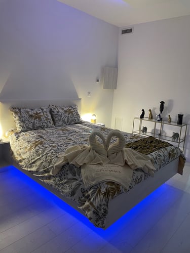 Bedroom with towel decoration for guests coming as couples, air conditioner in dim light at Domaine Des Lucques