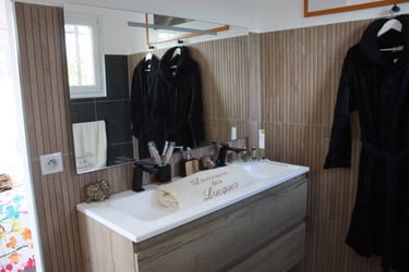 Bathroom equipped with grand mirror, sink, robe and sanitary items like shampoo, soap and toothbrush at Domaine Des Lucques