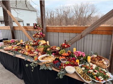 eight foot table covered in charcuterie and hummus, vegetables
