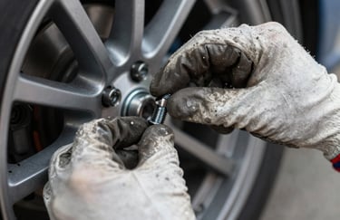 A close-up of a mechanic's hands in gloves precisely adjusting a wheel bolt, focus on expertise and professional service.