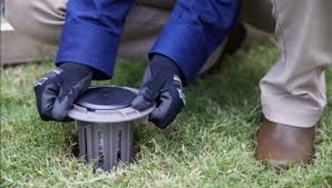 a technician installing Trelona ATBS termite stations